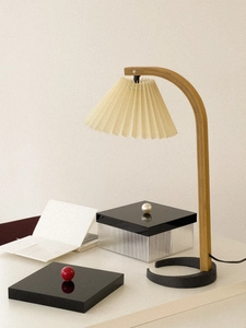 Detailed macro view of the pleated fabric lampshade and minimalist wooden lamp arm