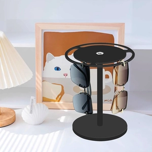 Rotating black sunglasses display stand with round base and tiered hooks for four glasses