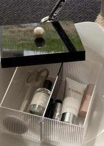 Macro view of fluted acrylic storage box with black mirrored lid and pearl handle detail