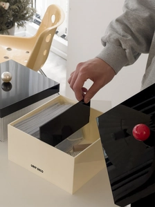 Detailed view of the acrylic cream storage box with a black lid and red spherical handle
