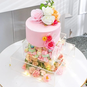 Detailed view of clear acrylic fillable cake stands with flowers and marshmallows inside