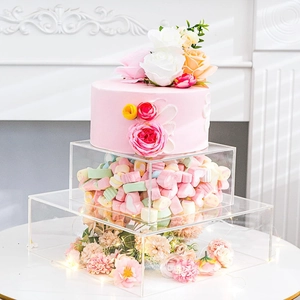 Detailed view of clear acrylic tiered cake stand filled with colorful flowers and lights