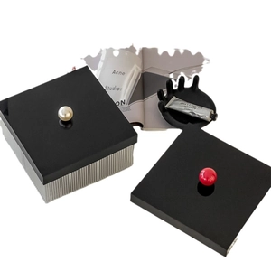 Modern acrylic storage box with silver wavy base and red pearl handle on black lid
