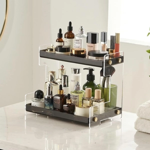 Modern two-tier acrylic organizer with black trays and gold accents for skincare items