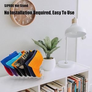 Clear acrylic baseball cap organizer stand holding seven hats on a white cabinet