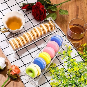 Macro view of clear acrylic rectangle serving tray with colorful macarons on checkered cloth