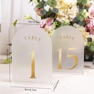 Detail of frosted arched acrylic wedding table numbers with gold foil lettering and base