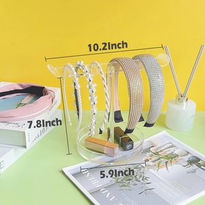 Clear acrylic T-bar headband organizer with five hairbands on a round base stand