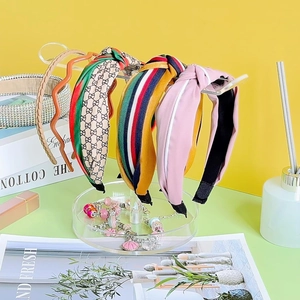 Detailed view of striped and monogram headbands on a clear acrylic organizer stand