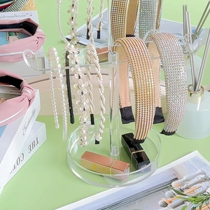 Macro shot of tiered acrylic headband holder organizer with various beaded hair bands