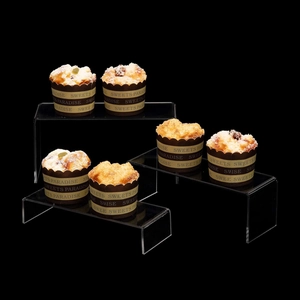 Macro shot of tiered U-shaped clear acrylic display stands on professional black background