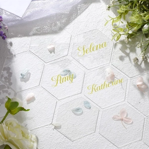 Customized clear hexagonal acrylic place cards with gold lettering for wedding banquet tables