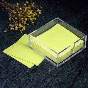 Clear acrylic napkin holder with U-shaped cutout on dark marble background