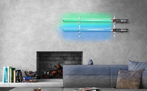 Detail showing wall-mounted acrylic rack with lit green and blue lightsabers on a wall