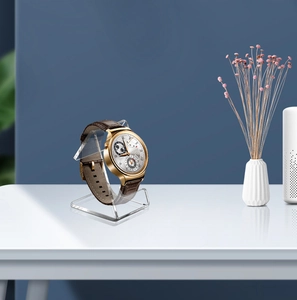 Detailed close-up of a clear acrylic watch stand display with a modern C-shaped design