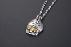 Detailed close-up of a vintage punk eagle pendant with hammered silver texture and gold star