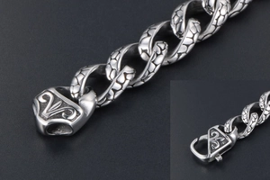 Detailed view of heavy stainless steel chain bracelet with textured scale links and engraved clasp