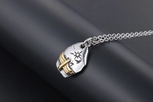 Close-up of vintage eagle necklace with gold wings and engraved star details