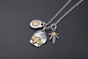 Detailed view of punk style eagle and leaf pendants on a coarse silver chain