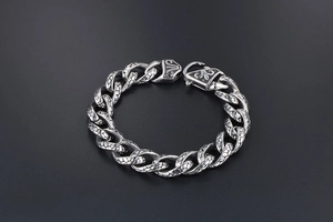 Detail of vintage silver chain bracelet with scale textures and gothic carvings