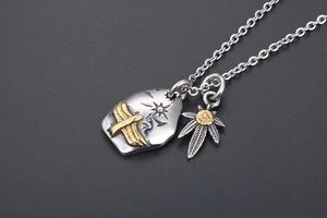 Macro shot of retro punk eagle and leaf pendants on a vintage silver chain necklace