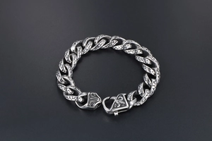 Macro view of stainless steel bracelet links with detailed dragon scale engravings