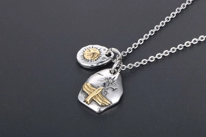 Close-up of retro eagle pendants with engraved star details on a fine silver chain