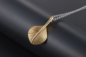 Macro shot of gold leaf pendant with fine veins and silver chain in dual-tone design