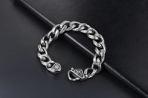 Detailed macro view of vintage leopard-engraved stainless steel links and floral buckle clasp