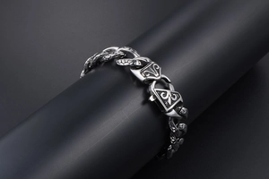 Detail of vintage stainless steel Cuban link bracelet with fleur-de-lis engraved clasp