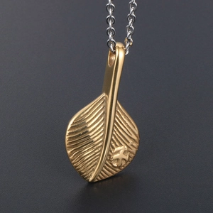 Vintage gold feather pendant necklace with silver chain and intricate engraved cross detail