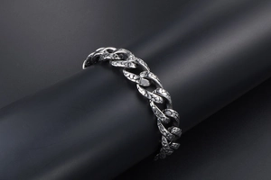 Close-up of vintage silver Cuban chain featuring intricate engraved snake scale textures