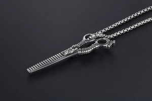 Detailed macro view of vintage stainless steel dragon scale scissors pendant with box chain