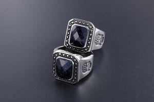 Detailed close-up of retro square blue sandstone ring with crown emblem on silver band