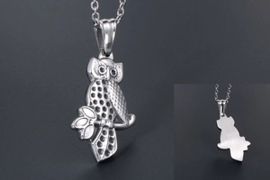 Macro detail of owl pendant with textured feathers and brushed metal finish on the back
