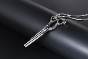 Detailed view of vintage punk dragon scissors and comb pendant with silver bead chain