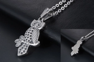 Detailed macro of silver owl pendant showing feather texture and smooth metallic back side