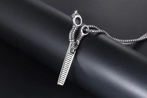 Macro shot of stainless steel comb pendant featuring an intricate dragon head engraving