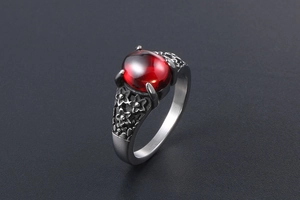 Macro detail of retro stainless steel ring with red gemstone and floral engravings