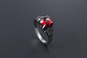 Detailed view of a vintage stainless steel ring with an oval red gemstone and floral engravings