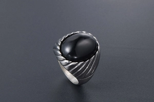 Close-up of vintage steel ring for men featuring an oval black agate stone and textured band
