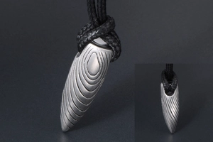 Détail du pendentif en forme de balle en acier inoxydable avec texture en métal mat