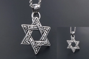 Close-up of vintage steel Star of David pendant with ornate relief and bead chain