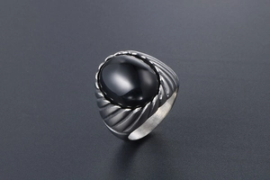 Macro detail of men's vintage silver steel ring with oval black onyx gemstone