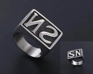 Macro shot of silver titanium steel square ring with embossed SN letter engraving