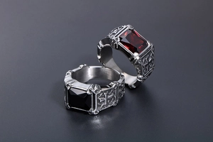 Macro shot of gothic steel rings with embossed crosses and red or black gemstones