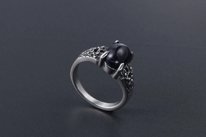 Detail of vintage stainless steel ring with blue sandstone and hollow flower carvings