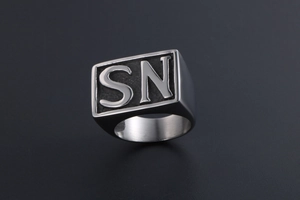 Macro detail of men's titanium steel ring with embossed SN letters on black textured base