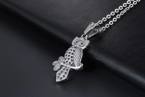 Macro view of detailed owl pendant on black leather texture showing fine textures