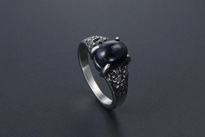 Macro shot of vintage steel ring featuring blue goldstone and floral engraved details